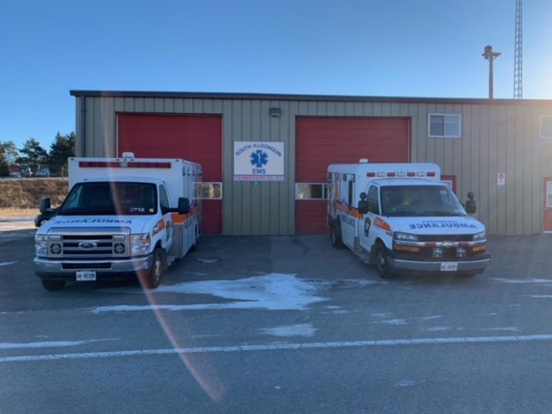 Two District of Nipissing ambulances in front of the South Algonquin Paramedic Services base. 