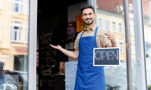 Shop owner holding open sign